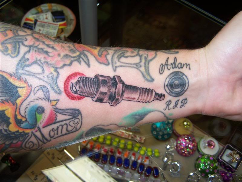 Memorial Spark Plug Tattoo On Left Forearm