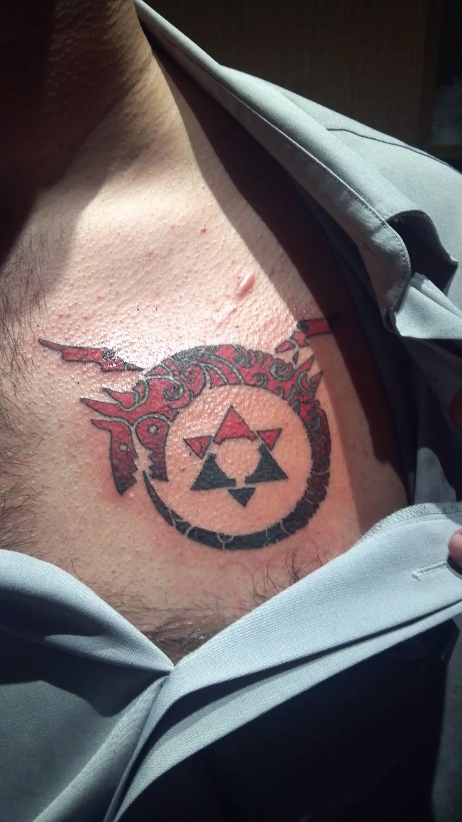 Black And Red Ink Ouroboros Tattoo On Man Chest