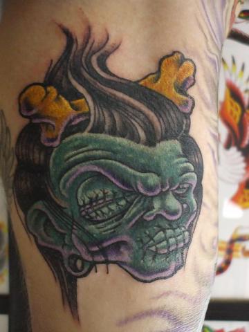 Green Ink Shrunken Head Tattoo Image