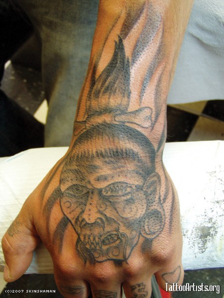 Grey Ink Shrunken Head Tattoo On Left Hand