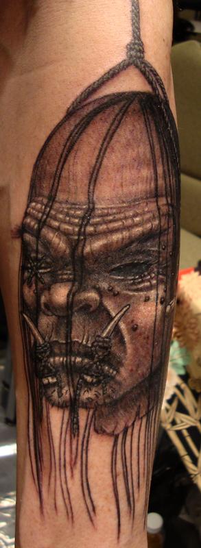 Grey Shrunken Head Tattoo On Left Forearm by Larry Brogan