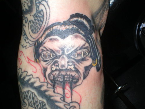 Grey Shrunken Head Tattoo On Leg