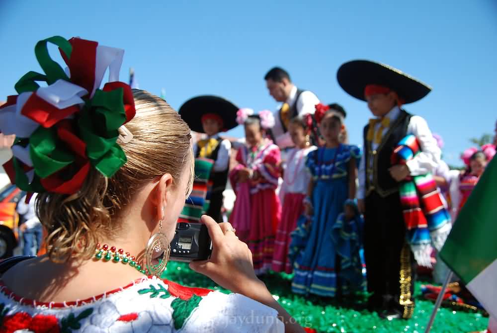 Girl Taking Picture Of Little Village Float During Mexican Independence Day Parade