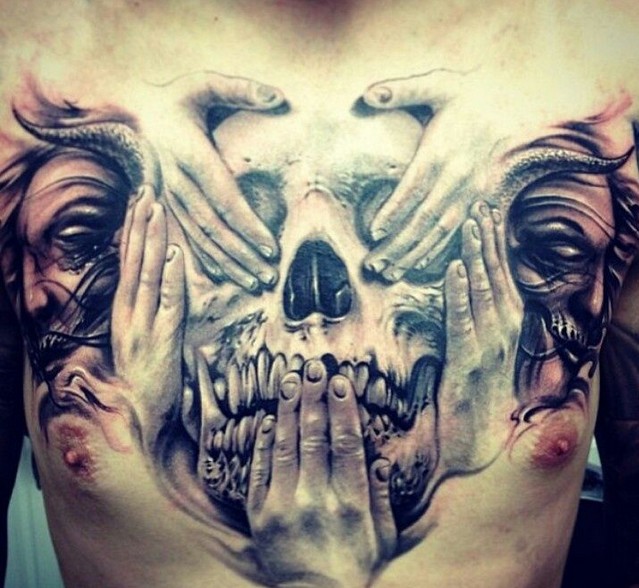 Skull and hands chest tattoo