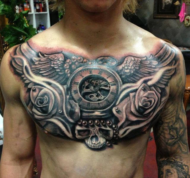 Wings with skull and flowers chest tattoo