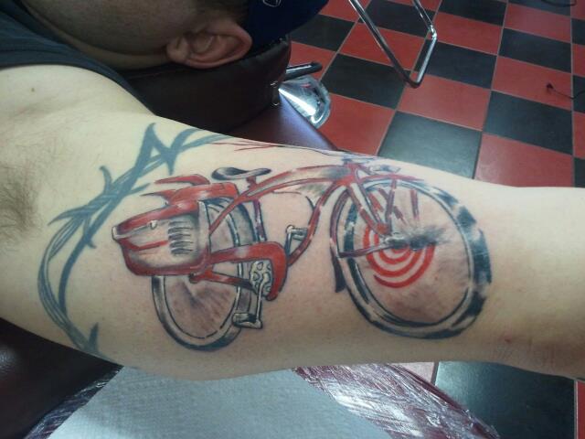 Black And Red Bicycle Tattoo On Left Bicep
