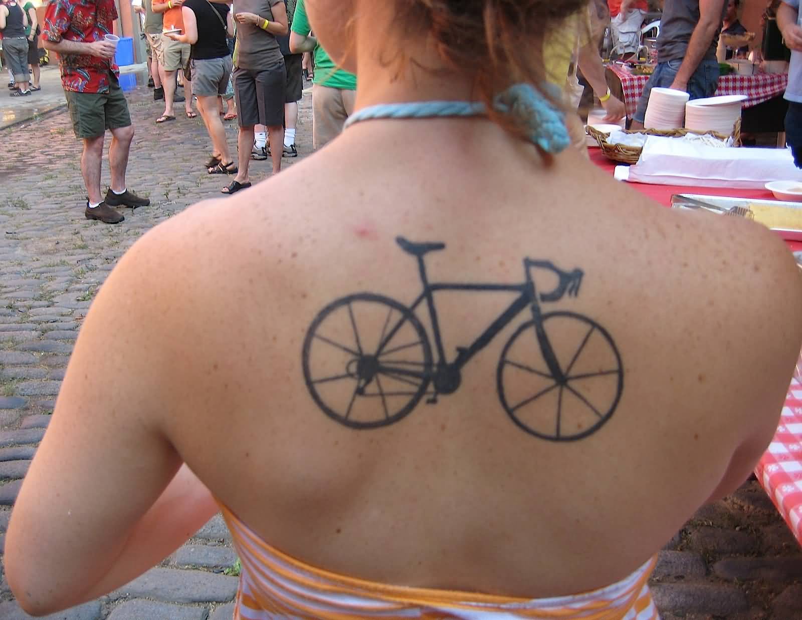 Black Ink Bicycle Tattoo On Girl Upper Back