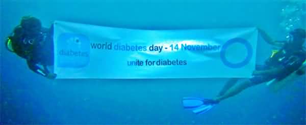 Divers Under Water With World Diabetes Day Banner