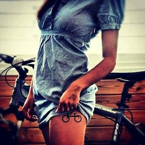 Girl Showing Her Bicycle Tattoo On Left Thigh