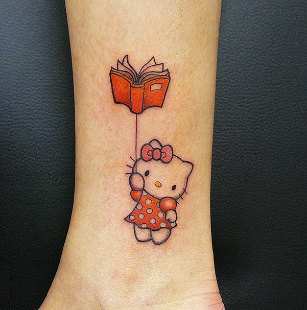 Hello Kitty With Book Tattoo On Leg.