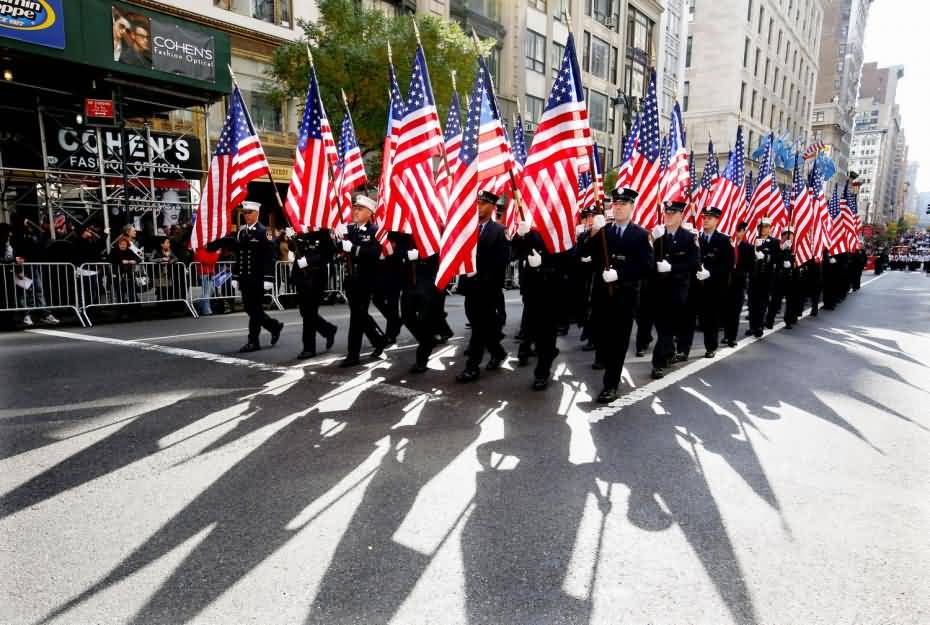 Soldiers With American Flags Marching During Veterans Day Parade