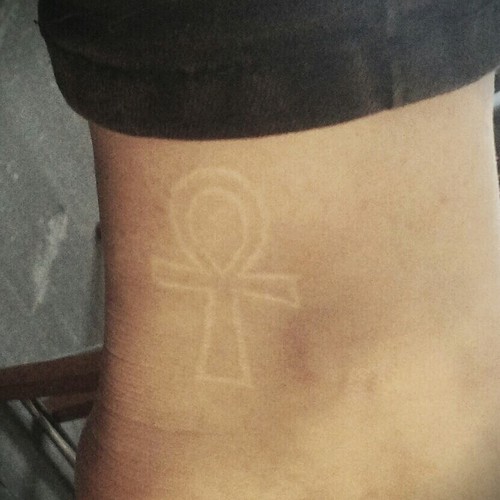 White Ink Ankh Tattoo On Ankle
