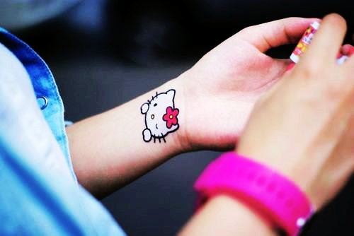 White Ink Hello Kitty Tattoo On Left Wrist