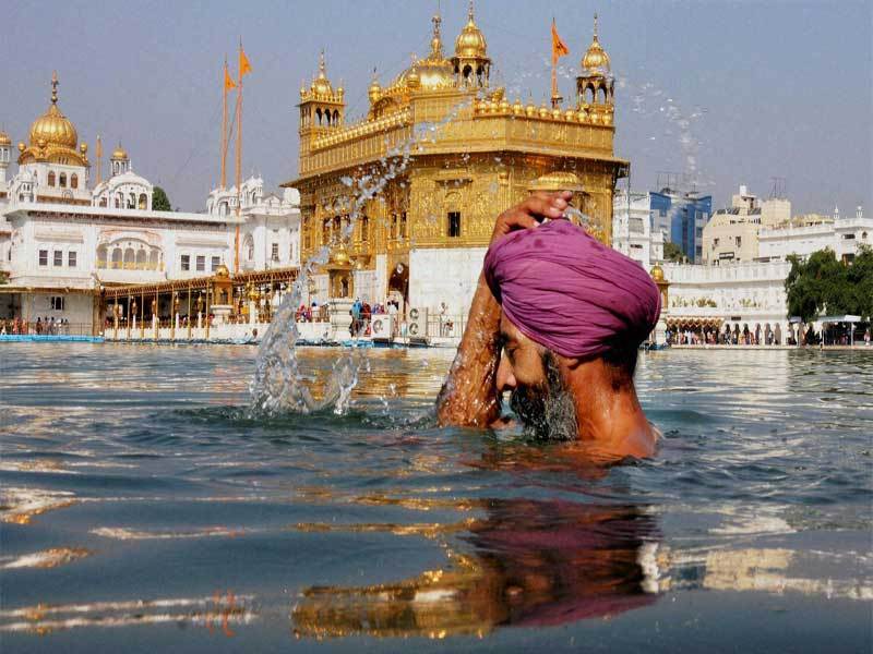 A Man Taking Bath In Holy Water During The Occasion Of Guru Nanak Jayanti