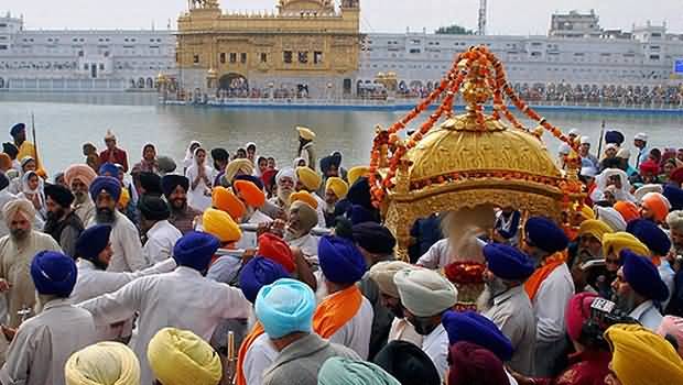 Sikh Devotees Carrying A Palanquim During Guru Nanak Jayanti Procession At The Golden Temple