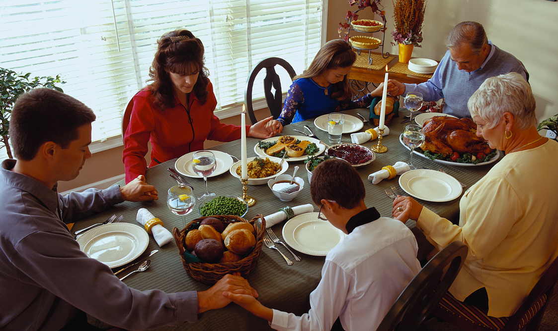 Family Praying Before Thanksgiving Dinner