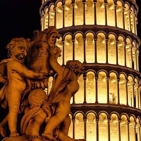 Closeup Of Angels Statue And Leaning Tower Of Pisa At Night