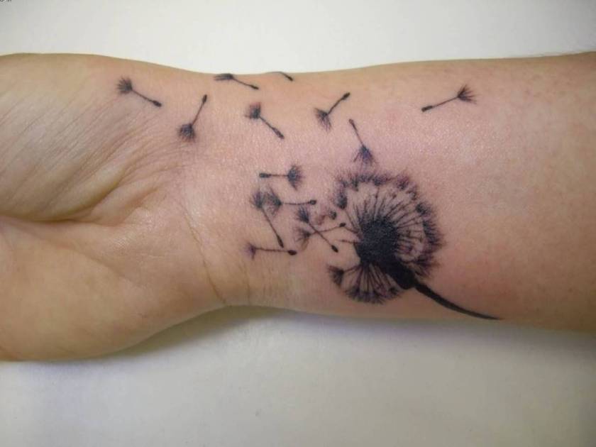 Amazing Shape Of Dandelion Blowing From Puff In Black Ink Tattoo On Wrist