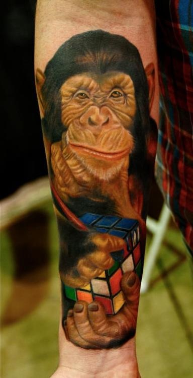 Beautiful Colored Chimpanzee With Rubik's Cube Tattoo On Forearm