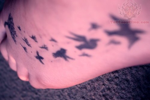 Birds Flying From Dandelion In Black Ink Tattoo On Foot
