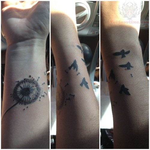 Birds Flying From Dandelion In Black Ink Tattoo On Side Wrist