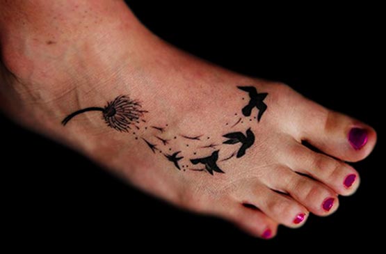 Birds Flying From Dandelion In Dark Black Ink Tattoo On Foot