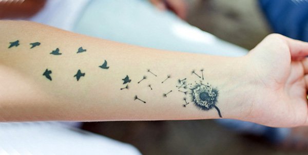 Birds Flying From Dandelion In Grey Ink Tattoo On Wrist To Forearm