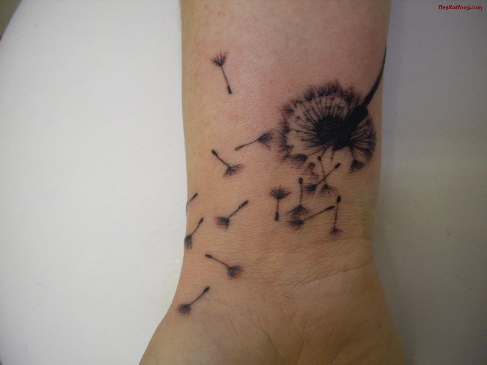 Dandelion Blowing From Puff In Black And Grey Ink Tattoo On Wrist