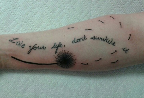 Dandelion Blowing From Puff With Quote In Green And Brown Ink Tattoo On Wrist