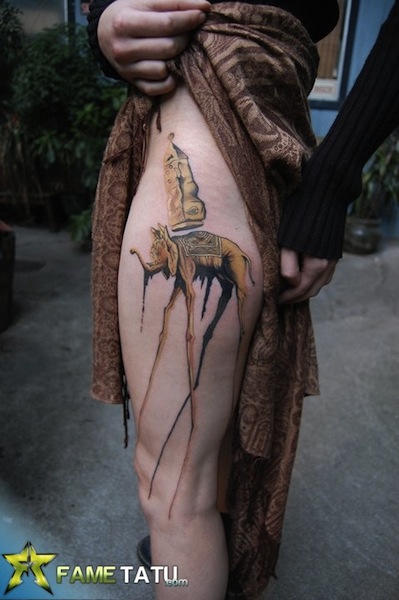 Girl Showing Dali Elephant Tattoo On Her Side Leg