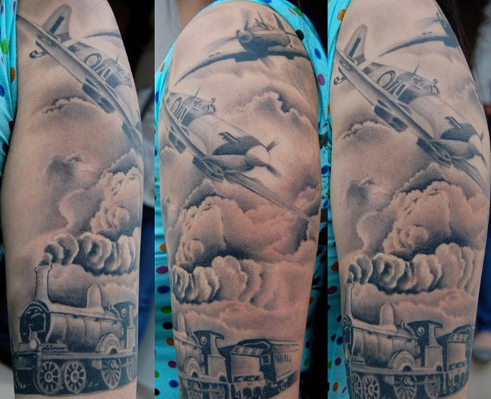 Grey Ink Train And Spitfire Tattoo On Half Sleeve