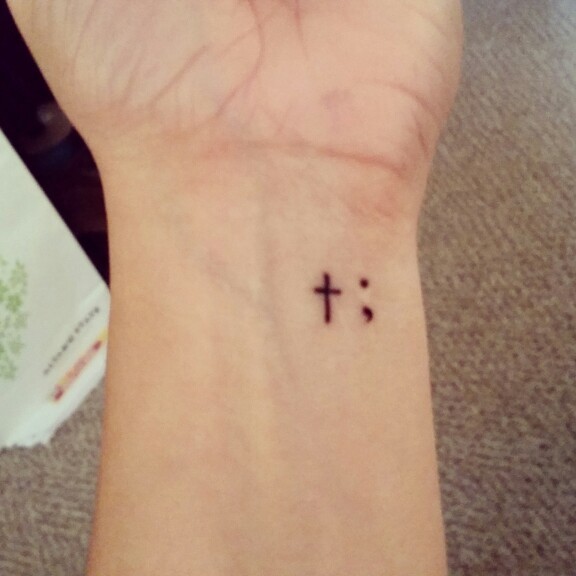 Small Cross And Semicolon Tattoo On Left Wrist