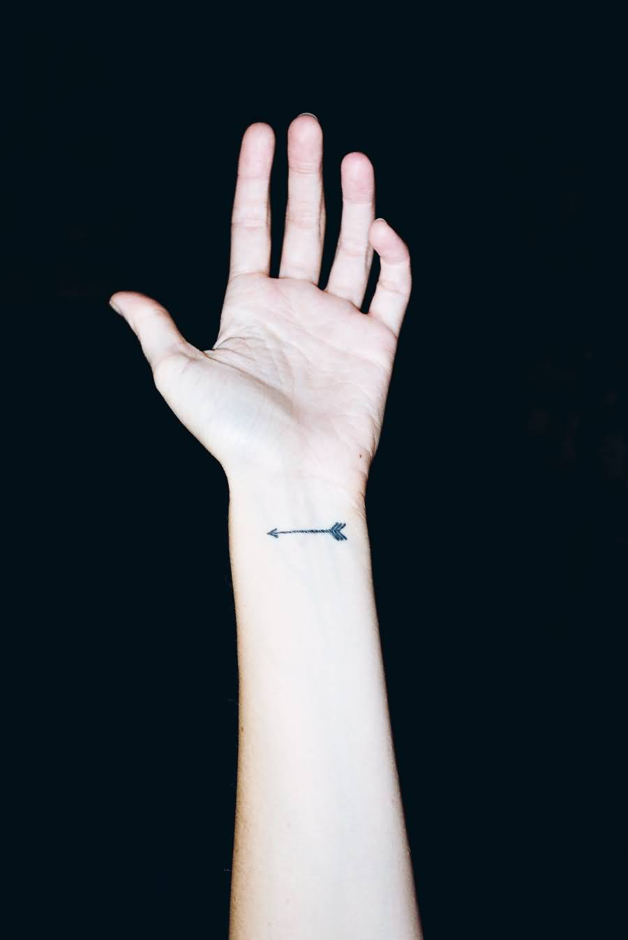 A Small Black Arrow Tattoo On Wrist