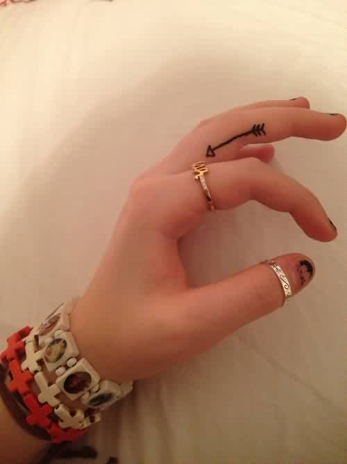 Attractive Thin Black Arrow Tattoo On Finger For Women