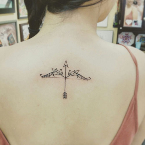 Beautifuly made Bow And Arrow Tattoo On Upper Back