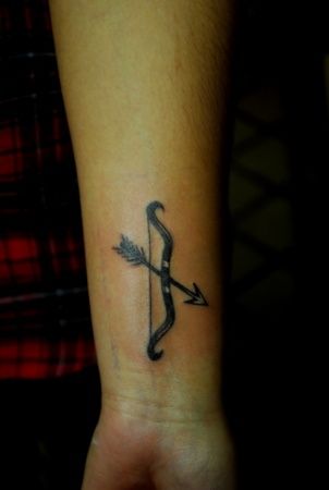 Black Ink Bow And Arrow Tattoo On Wrist