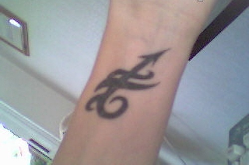 Black Ink Sagittarius Arrow And Tribal Tattoo On Wrist