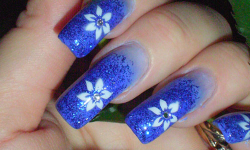 Blue Sparkle Nails With White Flower Nail Art