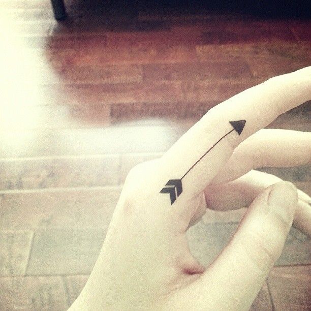 Cute Black Colored Arrow Tattoo On Finger