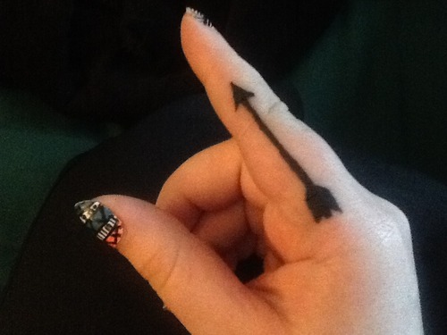 Dark Black Colored Arrow Tattoo On Index Finger