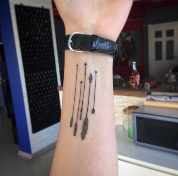 Few Black Arrows Tattoo On Wrist