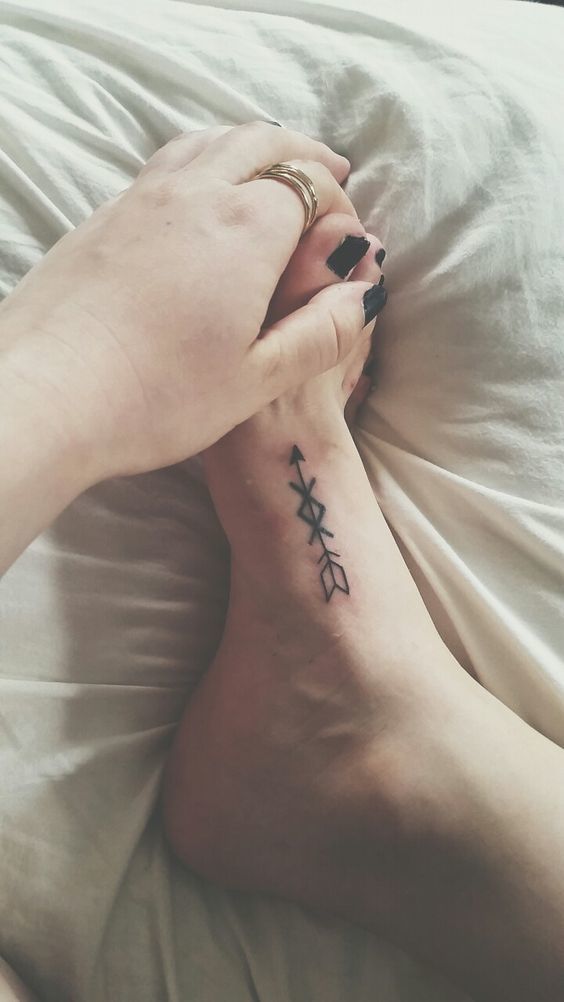 Impressive Black Ink Arrow Tattoo On Foot