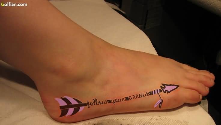 Lovely Pink Colored Arrow With Words Tattoo On Foot
