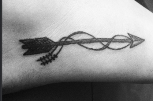 Simple Swirl Arrow Tattoo On Foot