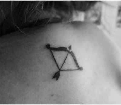 Small Bow And Arrow Tattoo On Upper Back