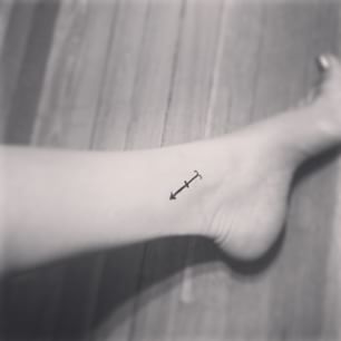 Tiny Black Color Arrow Tattoo On Ankle