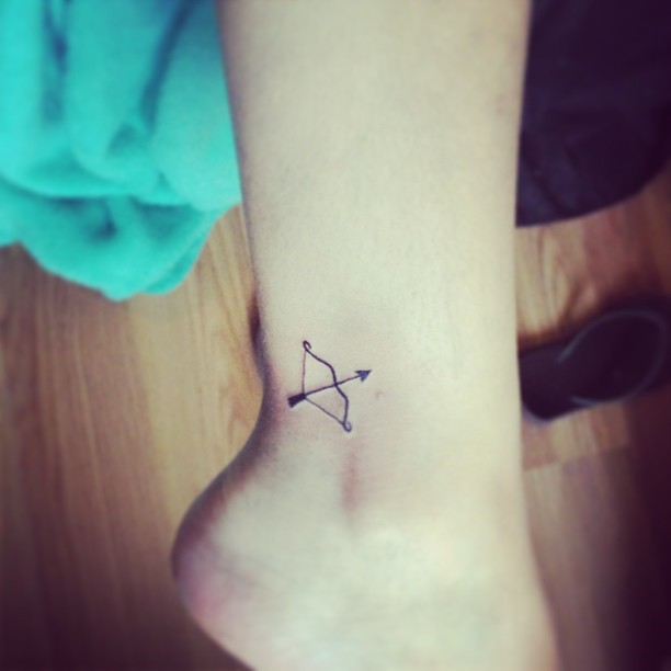 Tiny Bow And Arrow Tattoo On Ankle