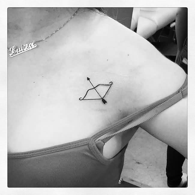 Tiny Bow And Arrow Tattoo On Left Shoulder