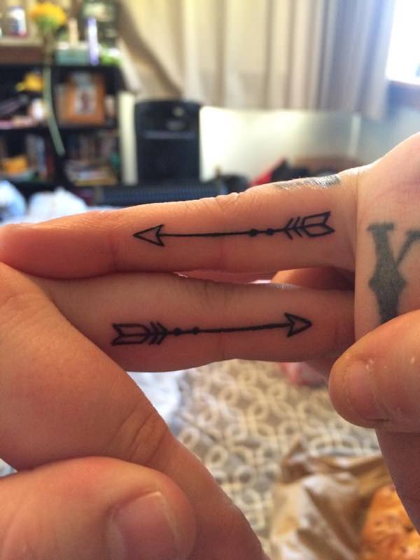 Two Black Ink Arrows Tattoos On Both Fingers