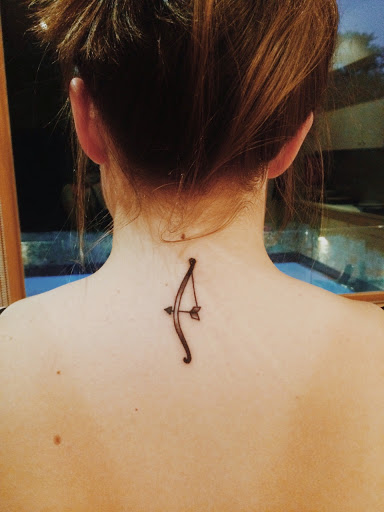 Very Cool Small Bow And Arrow Tattoo On Nape